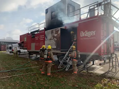  Mobile Live Fire Training Unit with firefighters standing outside