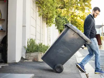 Man rollwing waste cart 