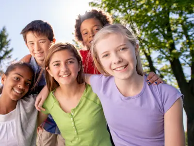 A happy group of children smiling and hanging out.